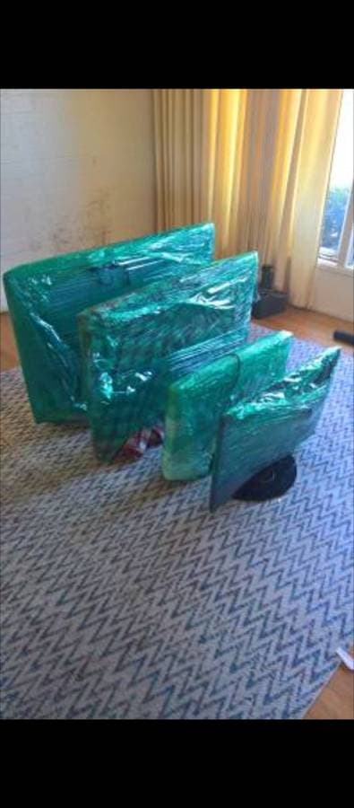 picture of televisions and monitors neatly wrapped up and ready to be moved by a moving company