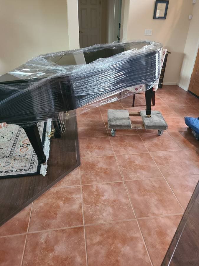 picture of a piano neatly wrapped and ready to be moved to another apartment