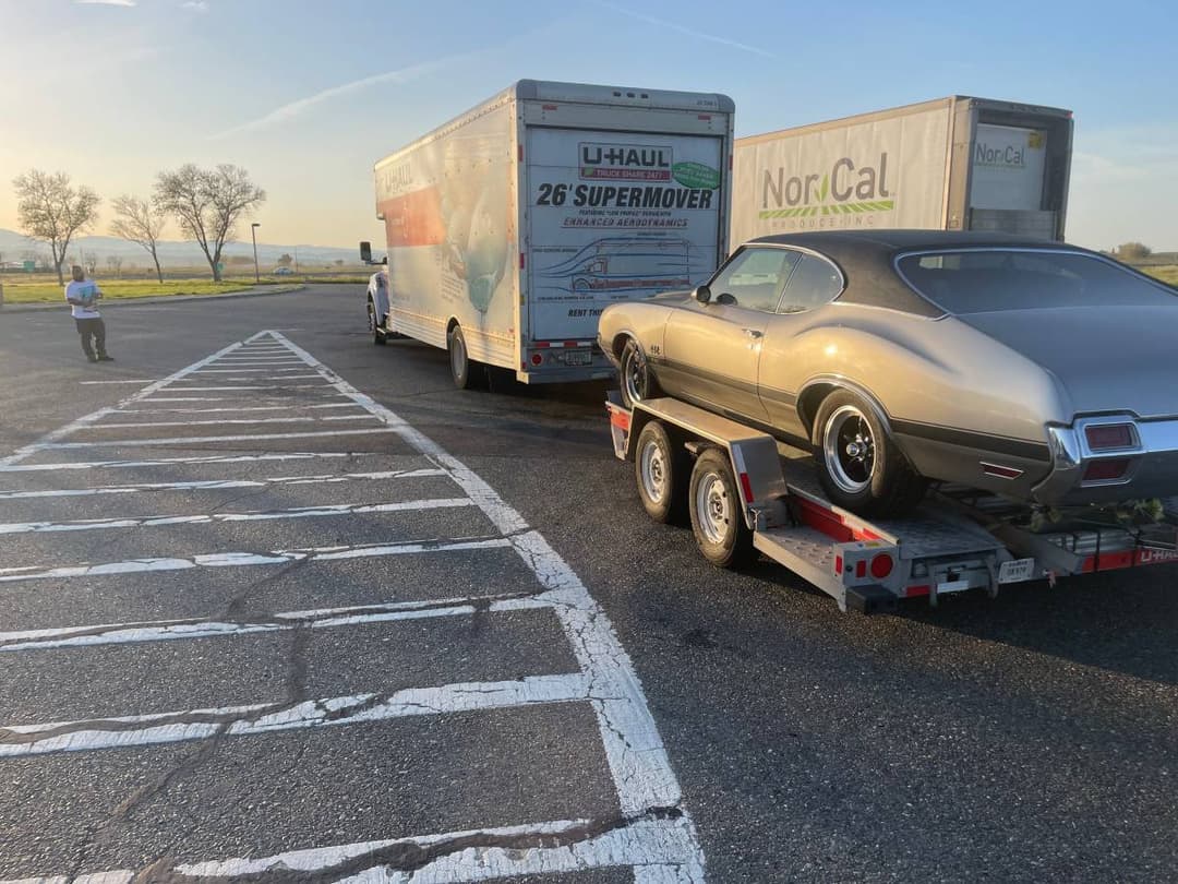 picture of a moving box truck with a trailer on the back that has a car on it.